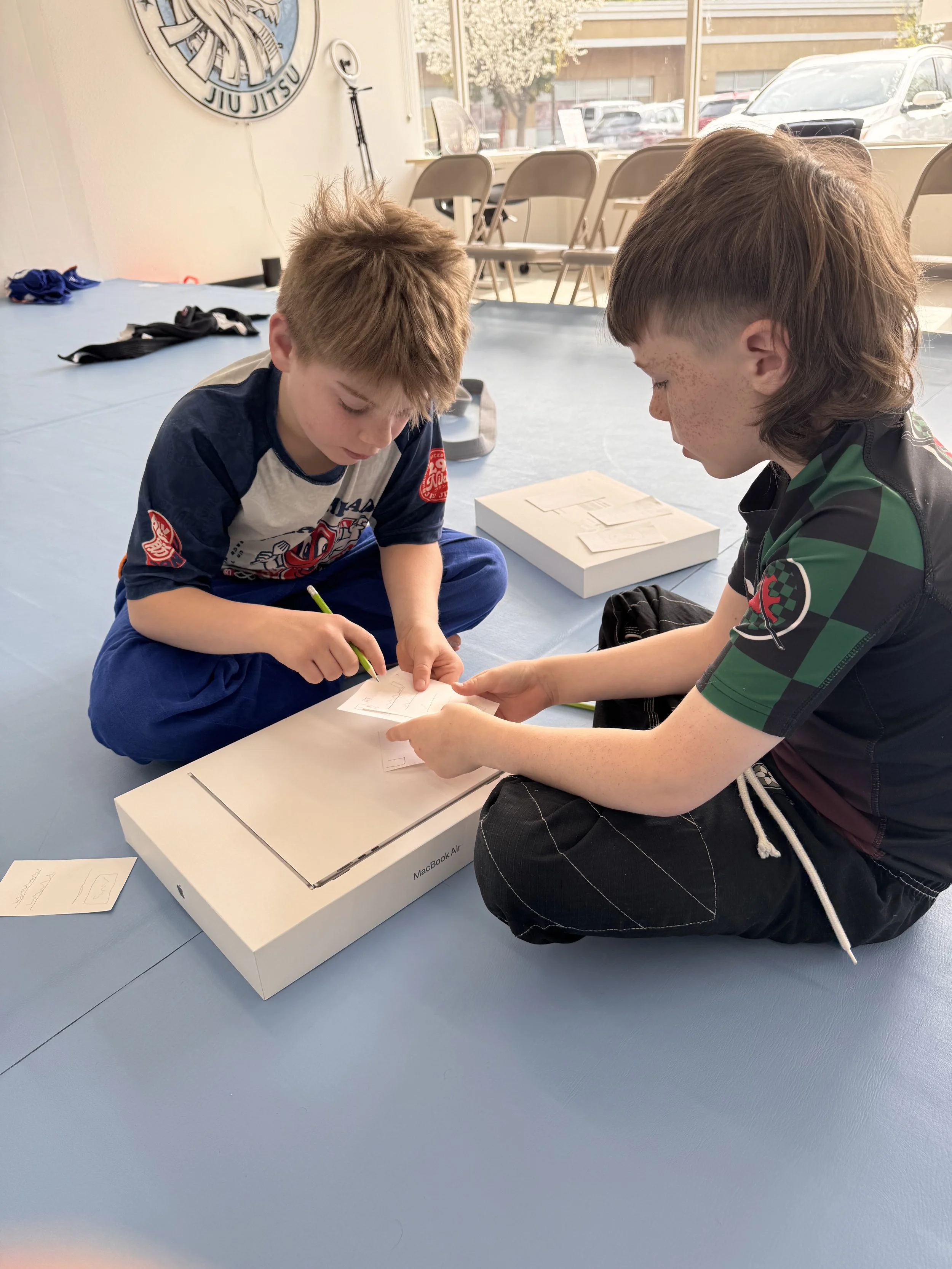Home-school students practicing Jiu Jitsu techniques together on the mats